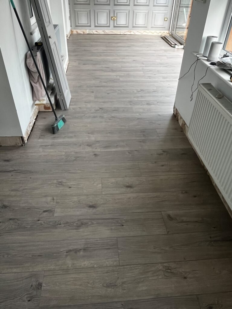 Grey oak laminate fitted continuously through the living areas of a home in Runcorn by Prime Carpets & Flooring