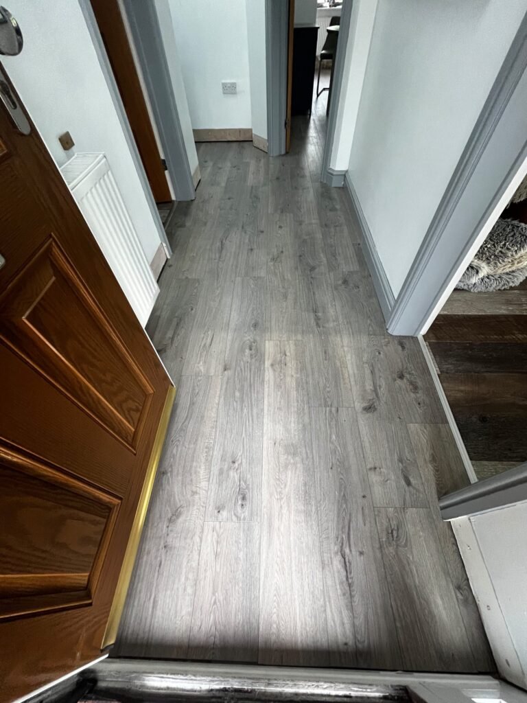 Grey oak laminate fitted through a hallway from the front door by Prime Carpets & Flooring