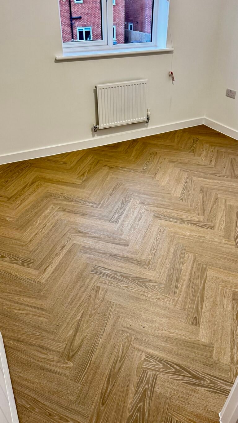 Natural oak herringbone LVT fitted in a bedroom