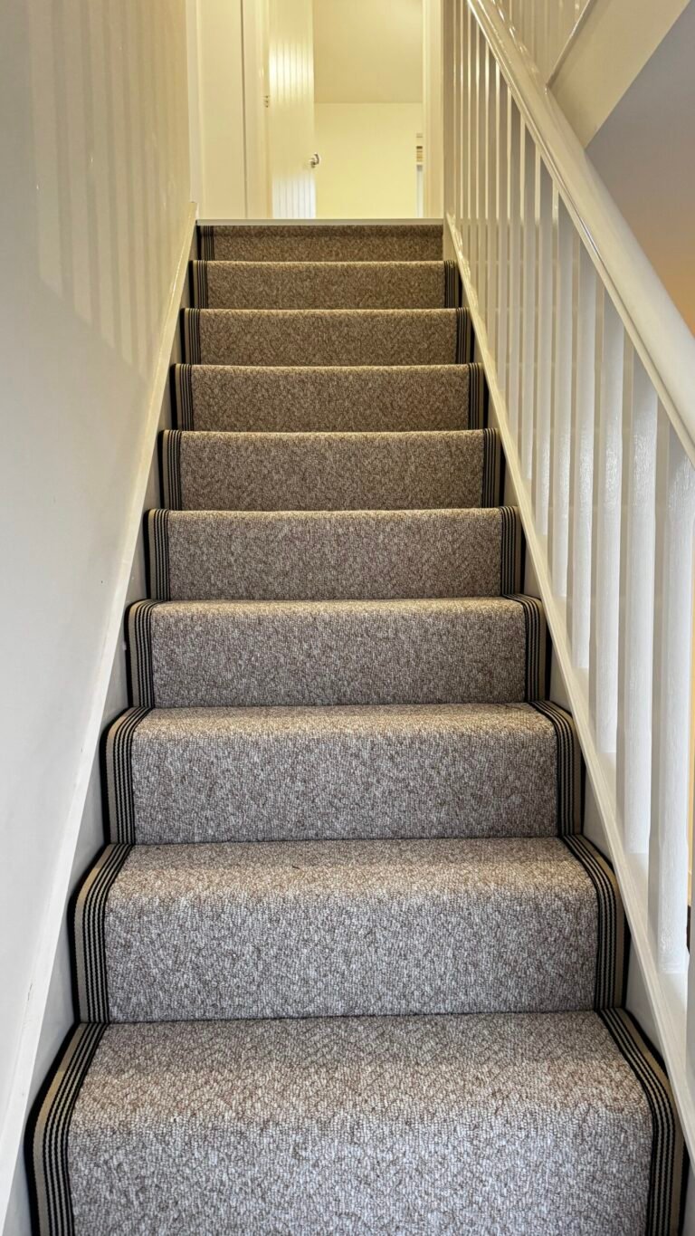 Grey stair runner with striped bound edges fitted on a staircase