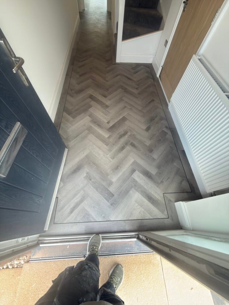 Grey herringbone LVT with a border fitted in an entrance hallway