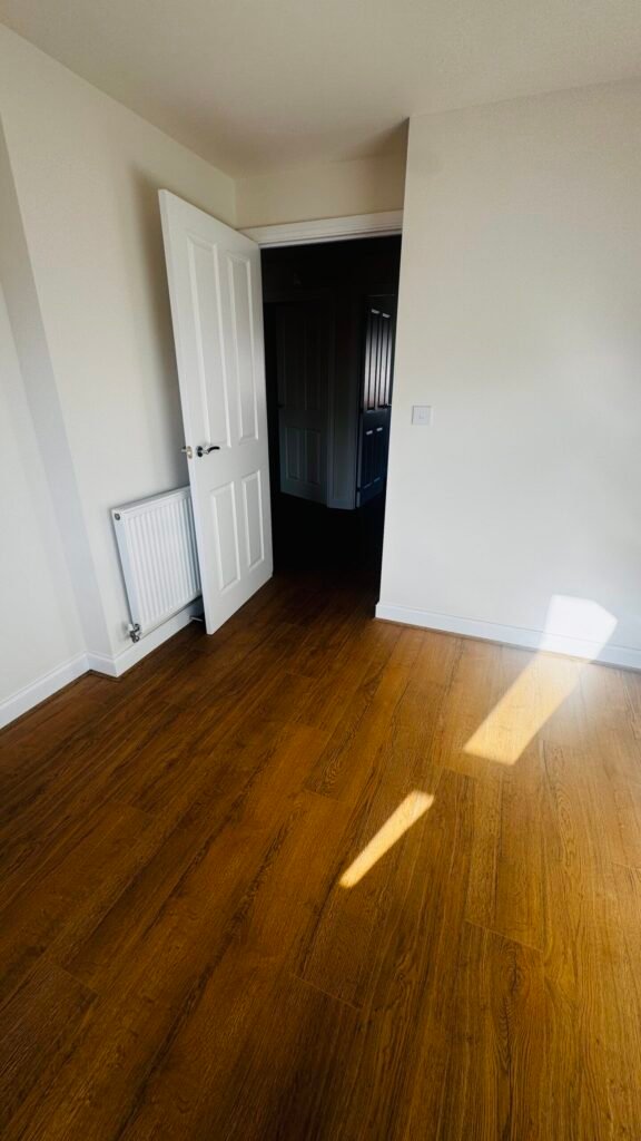 Dark oak laminate fitted in a bedroom by Prime Carpets & Flooring