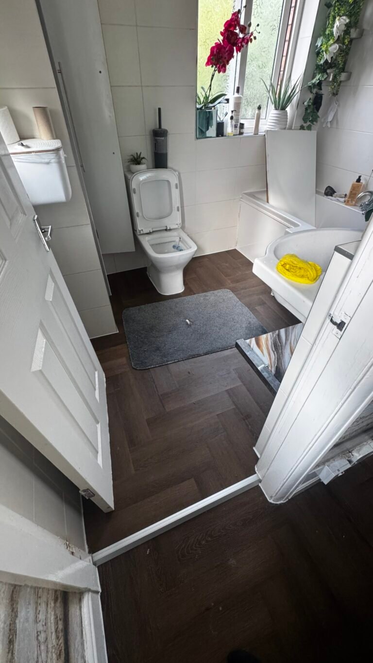 Dark oak herringbone glue-down LVT fitted in a bathroom