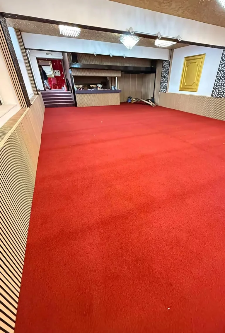 Red commercial carpet fitted wall to wall in a large hall in Warrington by Prime Carpets & Flooring